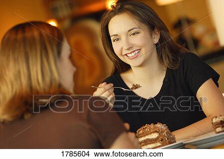 Two friends enjoying dessert View Large Photo Image Picture - Two friends enjoying dessert. Fotosearch