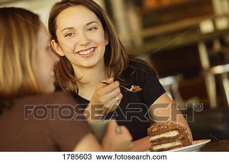 Two friends enjoying dessert View Large Photo Image Stock Image - Two friends enjoying dessert. Fotosearch