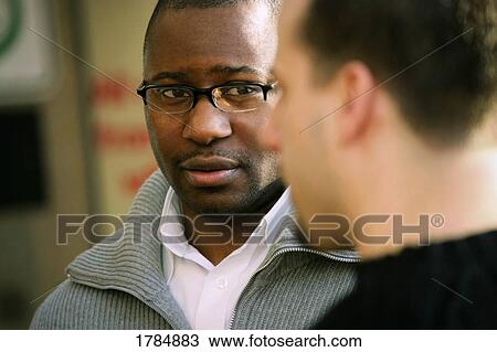 Stock Image - Two men conversing. Fotosearch