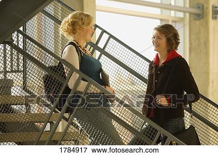 Stock Photo - Two students talking in stairwell. Fotosearch