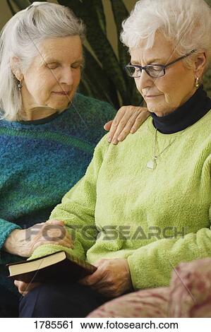 Stock Image - Two women in prayer. Fotosearch