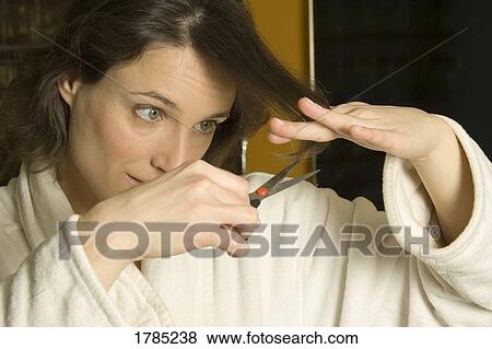 Woman cutting her hair View Large Photo Image Stock Photo - Woman cutting her hair. Fotosearch