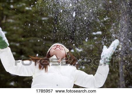Stock Photo - Woman enjoying the snow fall. Fotosearch