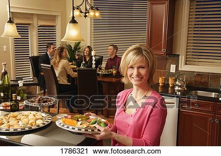 Stock Image - Woman entertaining a group of people. Fotosearch
