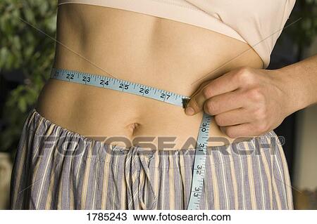 Woman measuring waist View Large Photo Image Stock Image - Woman measuring waist. Fotosearch