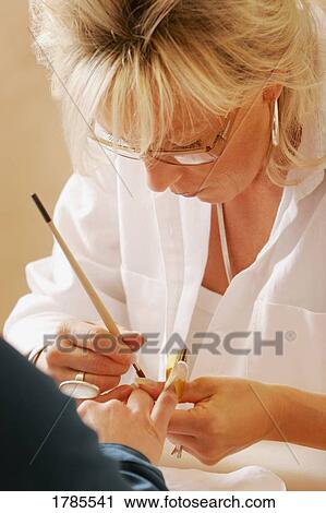 Stock Image - Woman painting fingernails. Fotosearch