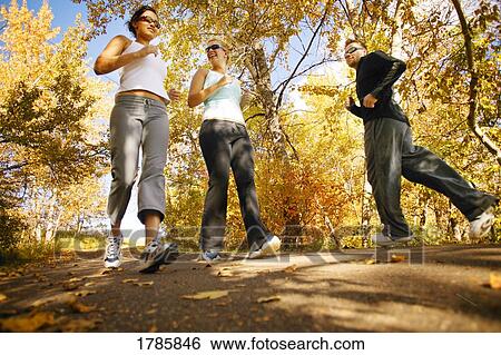 Stock Photograph - Young adults on running trail. Fotosearch