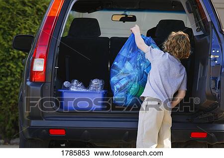 Stock Image - Young boy recycling. Fotosearch