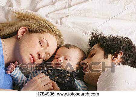 Young family sleeping together View Large Photo Image Stock Photograph - Young family sleeping together. Fotosearch