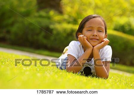 Young girl lying on grass View Large Photo Image Stock Photo - Young girl lying on grass. Fotosearch
