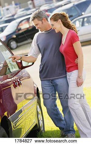 Stock Photo - Young married couple car shopping. Fotosearch
