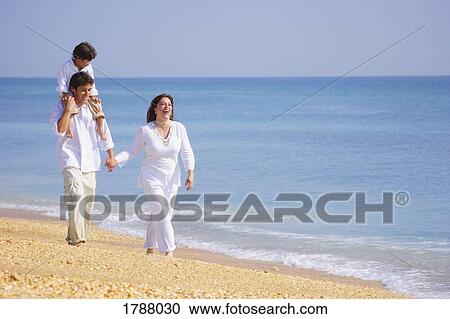 A family walks along the beach View Large Photo Image Stock Image - A family walks along the beach. Fotosearch