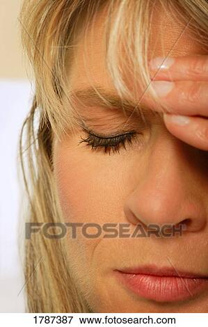 Stock Photo - A woman with her hand on her head. Fotosearch