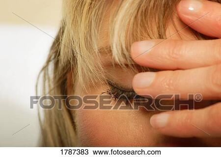 Stock Image - A woman with her head in her hand. Fotosearch