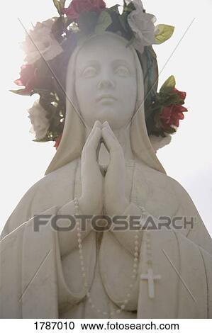 Stock Image - Adorned praying statue. Fotosearch