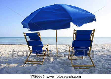 Stock Photography - Beach chairs and umbrella. Fotosearch