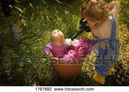 Big brother watering flowers View Large Photo Image Stock Image - Big brother watering flowers. Fotosearch