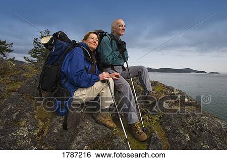 Couple resting from their hike View Large Photo Image Stock Photograph - Couple resting from their hike. Fotosearch