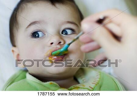 Stock Photography - Feeding baby. Fotosearch