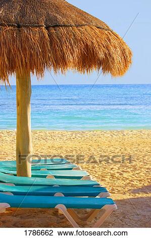 Grass hut & loungers on beach View Large Photo Image Stock Image - Grass hut & loungers on beach. Fotosearch
