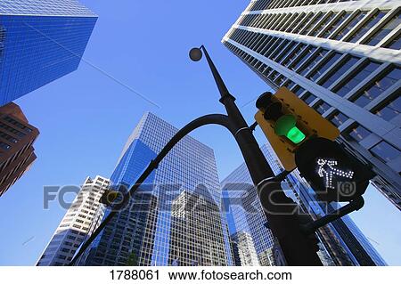 Stock Image - Green street light downtown. Fotosearch