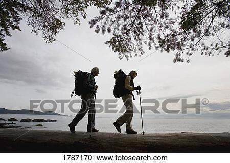 Stock Image - Hiking along a beach. Fotosearch