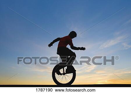 Stock Image - Man on unicycle. Fotosearch
