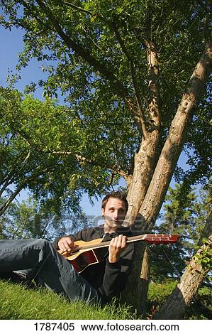 Man playing acoustic guitar View Large Photo Image Stock Photography - Man playing acoustic guitar. Fotosearch