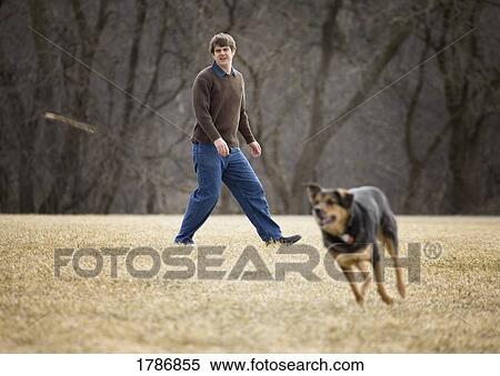 Stock Photography - Man throwing stick for dog. Fotosearch
