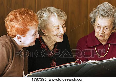 Seniors reminiscing over photo album View Large Photo Image Stock Photography - Seniors reminiscing over photo album. Fotosearch