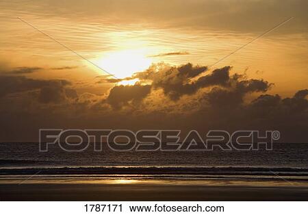 Stock Image - Sunset over beach. Fotosearch