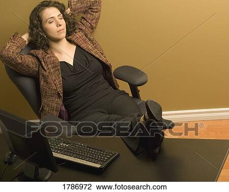 Stock Image - Woman resting at her desk. Fotosearch