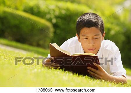 Stock Image - Young boy reading Bible. Fotosearch