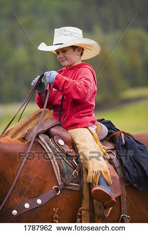 Stock Image - Young Cowboy on horse. Fotosearch