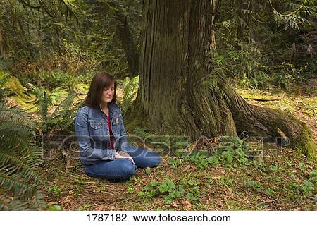 Stock Image - Young woman praying. Fotosearch