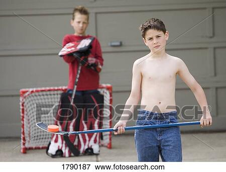 A boy rests a puck on his hockey stick View Large Photo Image Stock Photo - A boy rests a puck on his hockey stick. Fotosearch