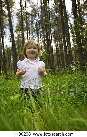 A little girl walking through tall grass View Large Photo Image Stock Photo - A little girl walking through tall grass. Fotosearch