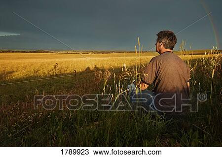 A man views the passing of a storm above the plain View Large Photo Image Stock Image - A man views the passing of a storm above the plain. Fotosearch