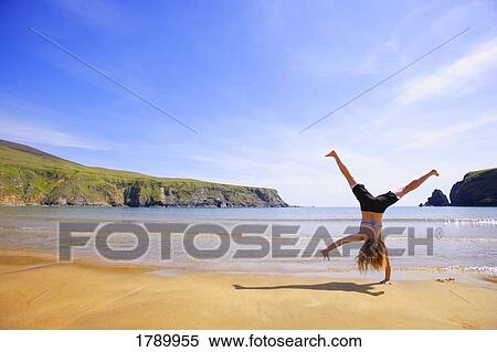 A teenager cartwheels along beach View Large Photo Image Stock Photography - A teenager cartwheels along beach. Fotosearch