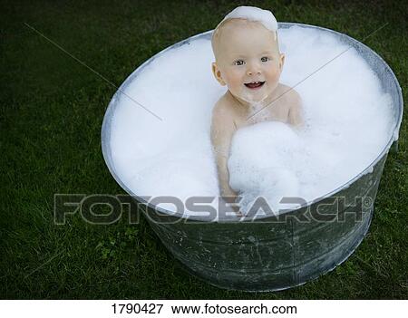 Stock Photo - Baby in a bath tub. Fotosearch
