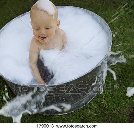 Stock Image - Baby in bubble bath. Fotosearch