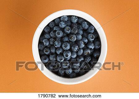 Blueberries in a white bowl on an orange background View Large Photo Image Stock Image - Blueberries in a white bowl on an orange background. Fotosearch
