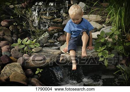 Boy by garden waterfall View Large Photo Image Picture - Boy by garden waterfall. Fotosearch
