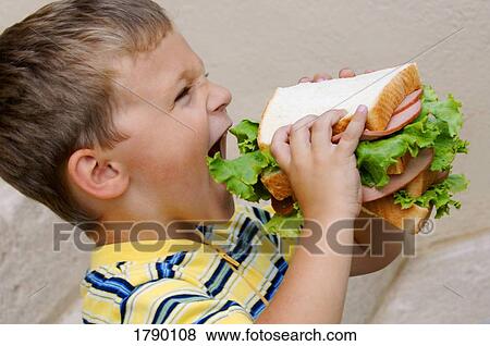 Stock Photo - Boy eating monster sandwich. Fotosearch