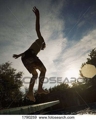 Stock Photo - Boy jumping off diving board. Fotosearch