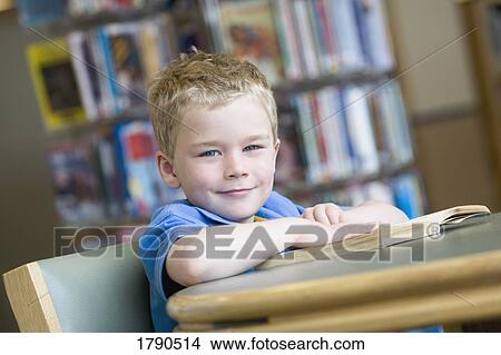 Boy reading book in library View Large Photo Image Picture - Boy reading book in library. Fotosearch