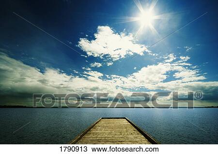 Bright sun over dock on lake View Large Photo Image Stock Image - Bright sun over dock on lake. Fotosearch