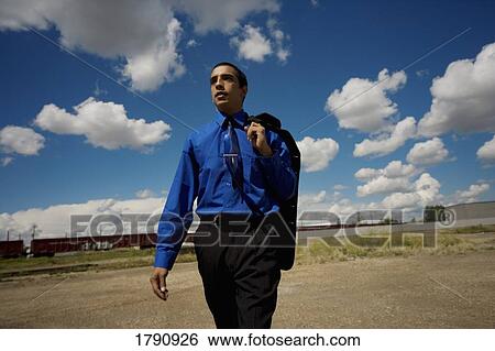 Business man walking by the railroad track View Large Photo Image Stock Photograph - Business man walking by the railroad track. Fotosearch