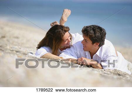 Couple laying on the beach View Large Photo Image Stock Image - Couple laying on the beach. Fotosearch