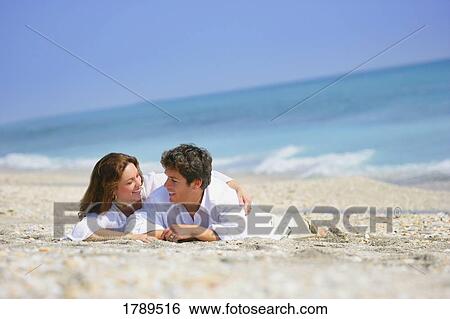 Stock Photograph - Couple Resting on Beach. Fotosearch